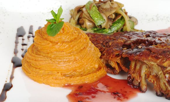 Sweet potato puree with rib covered by red sauce and fried vegetables (Selective Focus, Focus on puree and leaf, with parts of the meat being in focus, too)