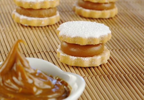 Peruvian cookie called Alfajor filled with a toffee-like cream called Manjar, with the cream in the front (Selective Focus, Focus on the alfajor in the middle)