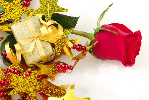 Red rose and golden present with christmas decoration on cotton (Selective Focus, Focus on rose and present)