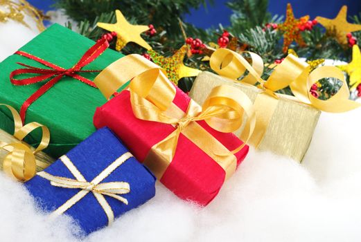 Colorful Christmas presents with Christmas decoration on cotton (Selective Focus, Focus on the blue and red boxes)