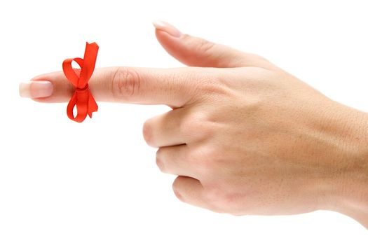 Finger with red bow pointing left. Isolated on a white background.