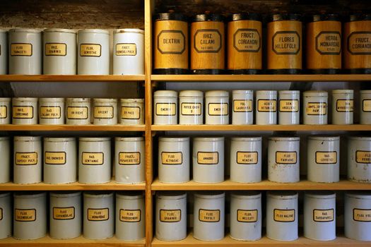 Background image of old pharmaceutical canisters used in creating medicine. Shot with ambient room lighting.
