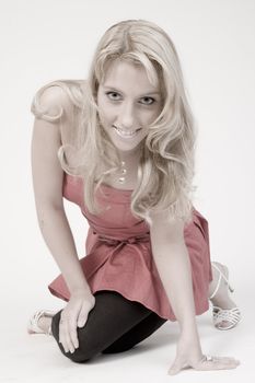Studio portrait of a long blond girl sitting on herk nee