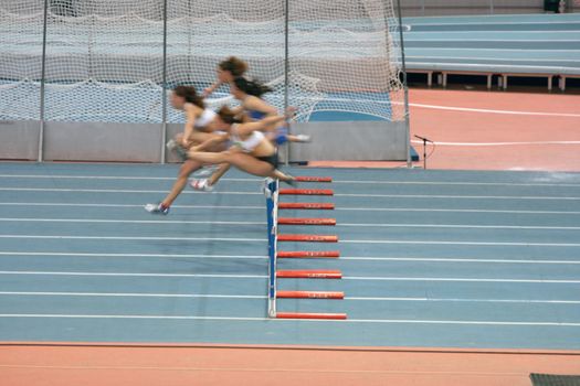 indoors women 60 meters low hurdlers race in action