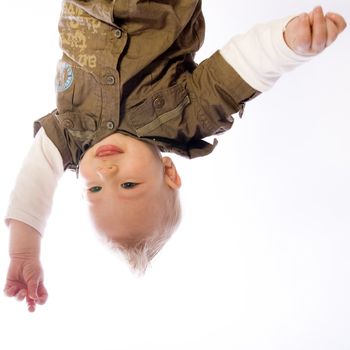 Studio portrait of baby boy hanging upside down