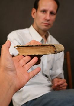 The old book in a hand of the woman and the man