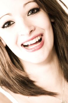 Studio portrait of pretty brunette laughing hard