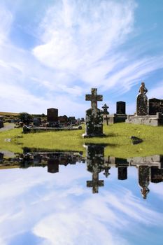 an old irish graveyard in Kerry on the west coast of Ireland reflected in water