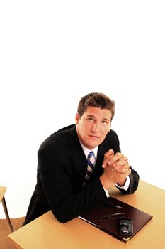 a man kneeling praying at his desk