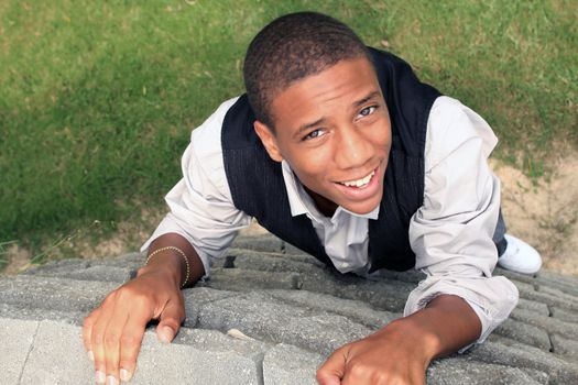 Man looking up smiling as he climbs wall