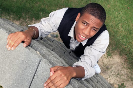 Man pulling himself up a wall