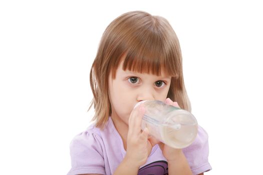 Little girl drinking water of her bottle. White background