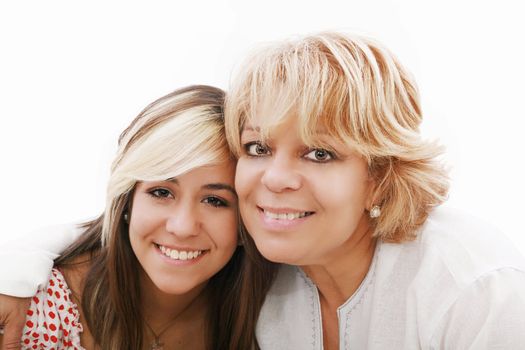 mother and attractive young daughter smiling happily, looking at camera