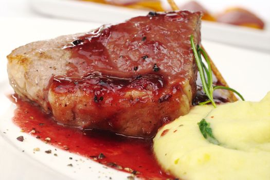 Mashed potato with meat, red sauce, fresh rosemary and a salt stick (Selective Focus, Focus on the front of the meat)   