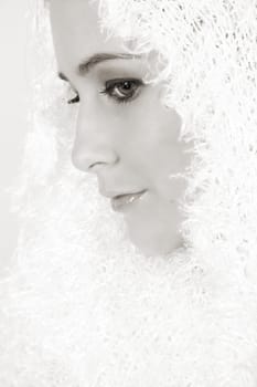 Beautiful young female model wrapped in white wool scarf