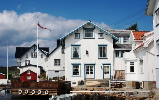 Typical white wooden houses on the shore in Lyngor, Southern Norway surrounded by small boats as these are the main means of transportation on the coast. 