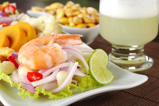 Peruvian ceviche with king prawn accompanied by sweet potatoes, corn, cancha (fried corn) and the Peruvian cocktail called "Pisco Sour" (Selective Focus, Focus on the front of king prawn)