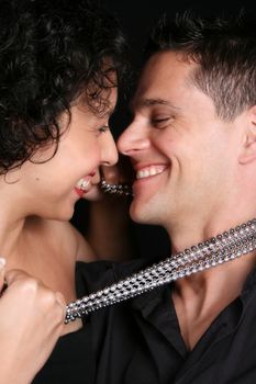 Beautiful young couple laughing with their faces close to one another
