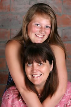 Portrait of mother and daughter against a brick wall background