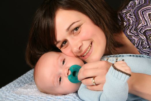 Beautiful brunette mother with her baby boy dressed in blue 
