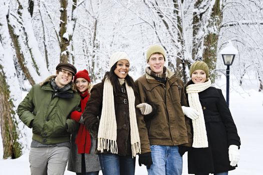 Group of diverse young friends walking outdoors in winter park