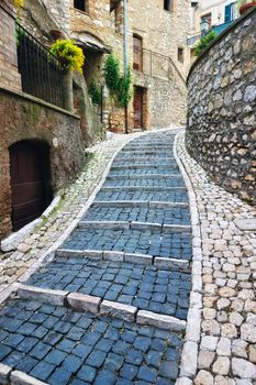 Sidewalk between old homes paved with the cobblestones