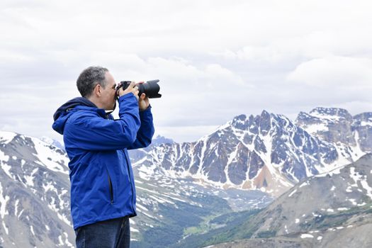 Male photographer taking pictures in Canadian Rocky Mountains in Jasper National Park