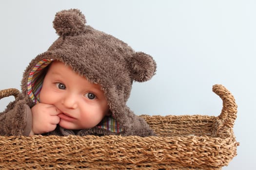 Four month old baby boy wearing a fully bear suit 