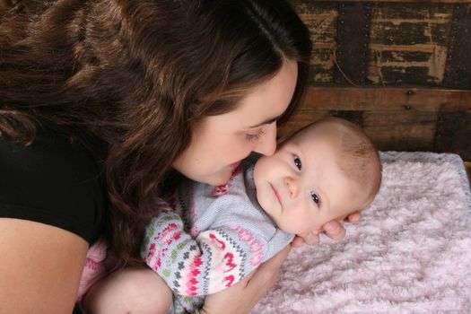 Brunette mother lovingly holding her baby girl