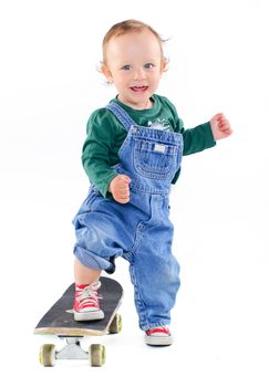 Cute 1 years old boy on a skateboard in the studio