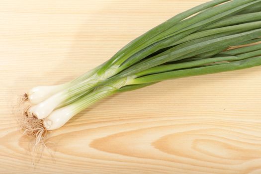 bunch of spring onions on a wooden table