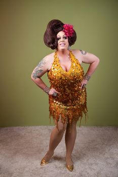 Confident drag queen with hands on hips over green background