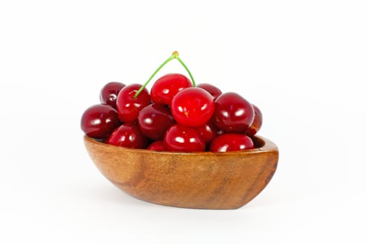 Sweet cherries in wooden bowl isolated on white