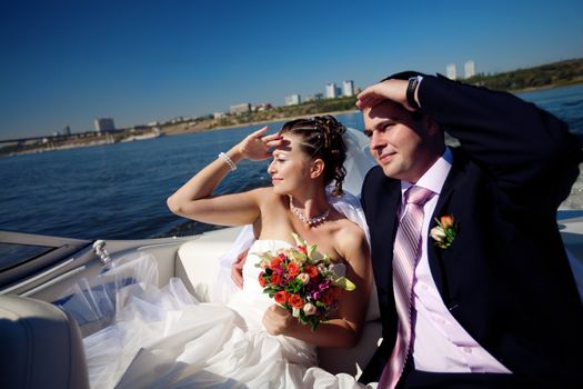happy bride and groom looking forward on the boat