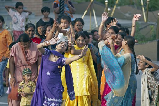 Indian women dancing in the street as part of the ceremony closing the border between India and Pakistan at Wagah in Punjab, India