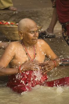 Man bathing in the sacred River Ganges on in the sacred city of Varanasi, Uttar Pradesh, India