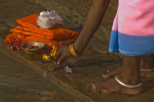 Woman making an offering and praying to the gods on the ghats at Varanasi India