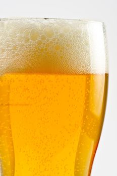 Glass of beer closeup on a white background
