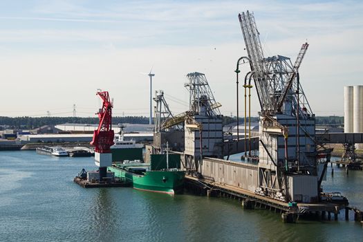 Ship getting loaded  with grain at terminal - grain elevator in background