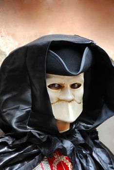 portrait of male adult doll in scary mouthless mask on street in Venice, Italy