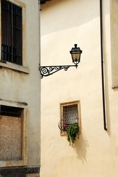street lamp on building corner and small window, architecture details of Verona, Italy