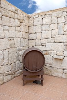 An old Wine Barrel in a Greek Courtyard under a blue summer Sky