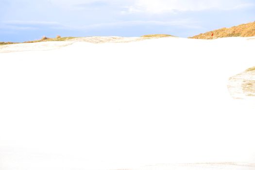 a snow covered links golf hole in ireland in winter weather with red flag