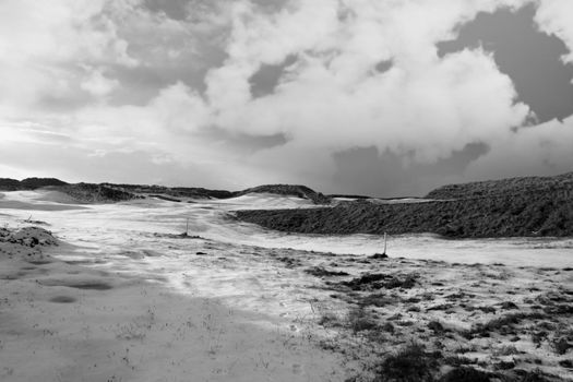 a snow covered with stormy sky links golf course in ireland in winter in black and white