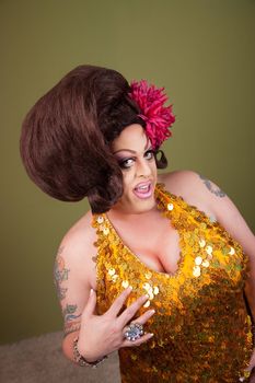 Flamboyant drag queen standing over a green background 