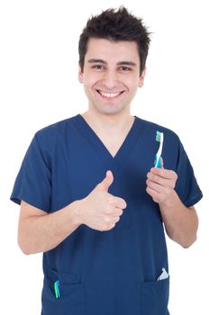 smiling male dentist holding toothbrush and showing thumb up isolated on white background