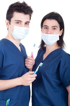 friendly team of dentists, doctors wearing mask holding toothbrush isolated on white background
