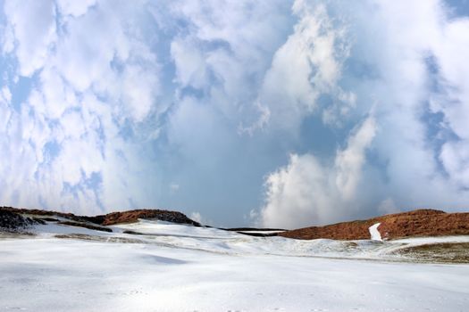 yellow flag on a snow covered with stormy sky links golf course in ireland in winter