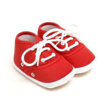 An isolated pair of red baby shoes for the newborn to wear.