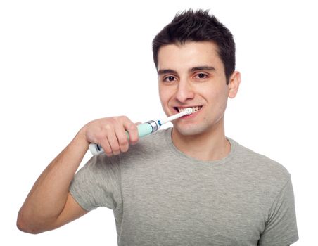 handsome young man brushing his teeth with electric toothbrush (isolated on white background)